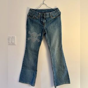 Denim jeans with rhinestone skull on thigh